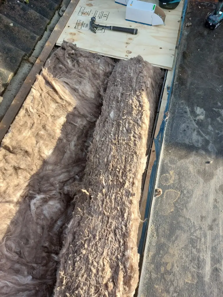 Open dak tijdens een renovatie, met de isolatie in zicht